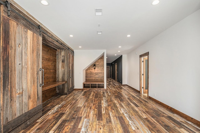 4035 136th Ave, Hamilton, MI 49419 - unfurnished living room with a barn door, hardwood / wood-style floors, recessed lighting, baseboards, and wood walls