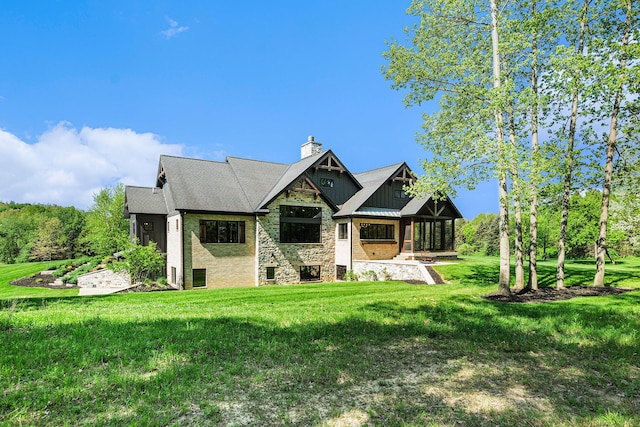 4035 136th Ave, Hamilton, MI 49419 - view of front of home with board and batten siding, a chimney, a front yard, and stone siding