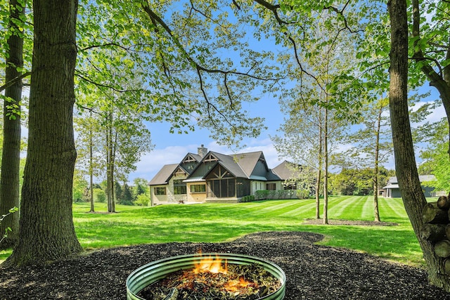 4035 136th Ave, Hamilton, MI 49419 - rear view of property with a yard, a chimney, and an outdoor fire pit