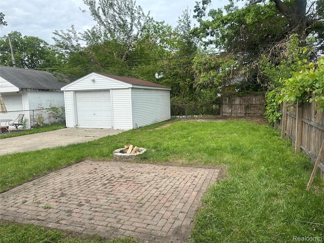 23767 Battelle Ave, Royal Oak, MI 48030 - view of yard with a garage, driveway, an outbuilding, and an outdoor fire pit