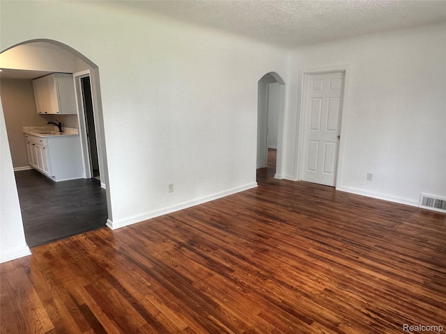 23767 Battelle Ave, Royal Oak, MI 48030 - unfurnished room featuring a sink, arched walkways, dark wood finished floors, and baseboards