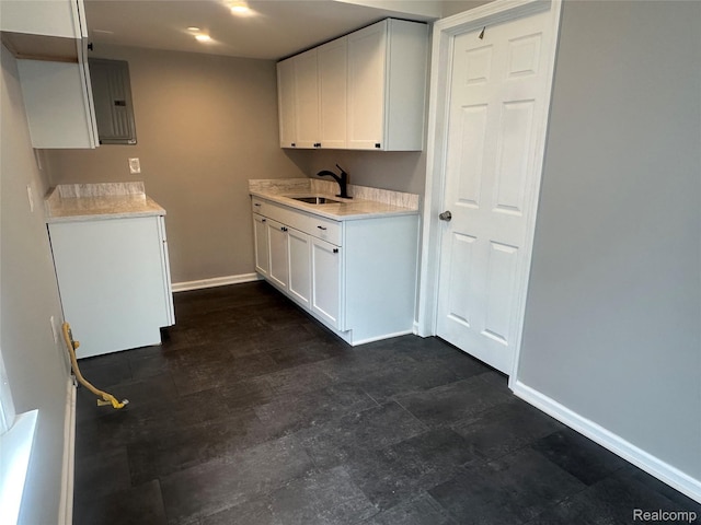 23767 Battelle Ave, Royal Oak, MI 48030 - kitchen featuring a sink, baseboards, light countertops, white cabinets, and electric panel