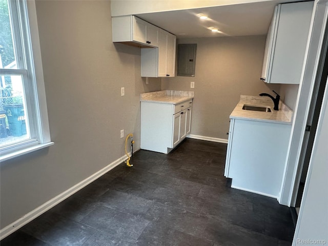 23767 Battelle Ave, Royal Oak, MI 48030 - kitchen featuring a sink, electric panel, baseboards, and light countertops