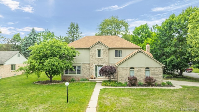 8924 Woods Edge Dr, Commerce Twp, MI 48382 - view of front of home featuring a front yard, a chimney, and brick siding