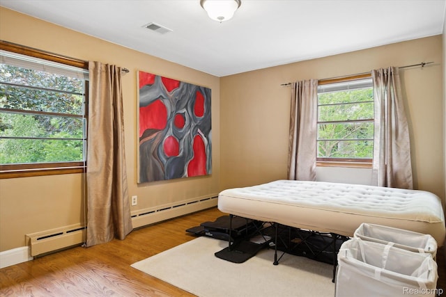 1220 Minglewood Way, Ann Arbor, MI 48103 - bedroom featuring wood finished floors, a baseboard radiator, and baseboards