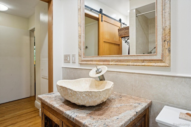 1220 Minglewood Way, Ann Arbor, MI 48103 - full bath featuring wood finished floors, vanity, toilet, tile walls, and a shower