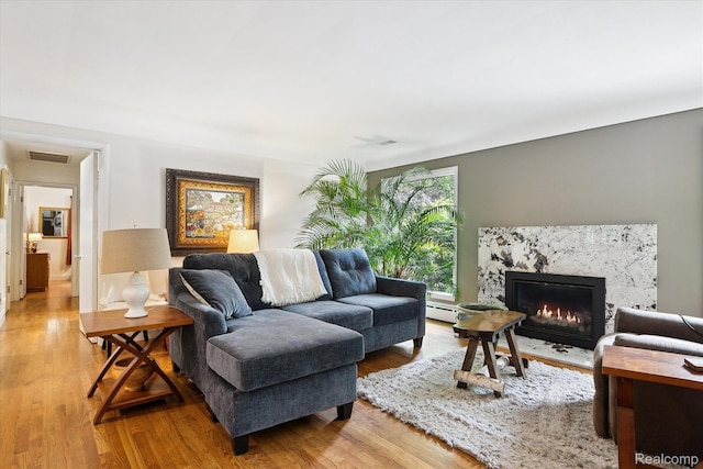 1220 Minglewood Way, Ann Arbor, MI 48103 - living area with light wood-style flooring, a fireplace, and a baseboard heating unit