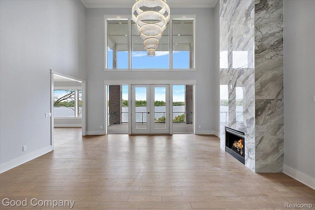 1760 Hamilton Dr, Bloomfield Hills, MI 48302 - unfurnished living room featuring a fireplace, hardwood / wood-style flooring, a towering ceiling, and baseboards