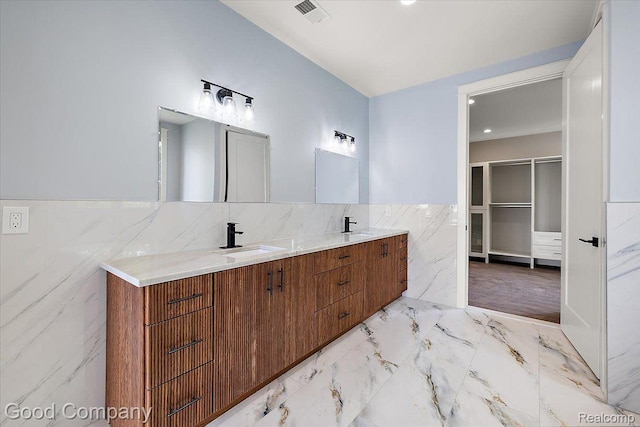1760 Hamilton Dr, Bloomfield Hills, MI 48302 - bathroom featuring tile walls, double vanity, marble finish floors, wainscoting, and a walk in closet