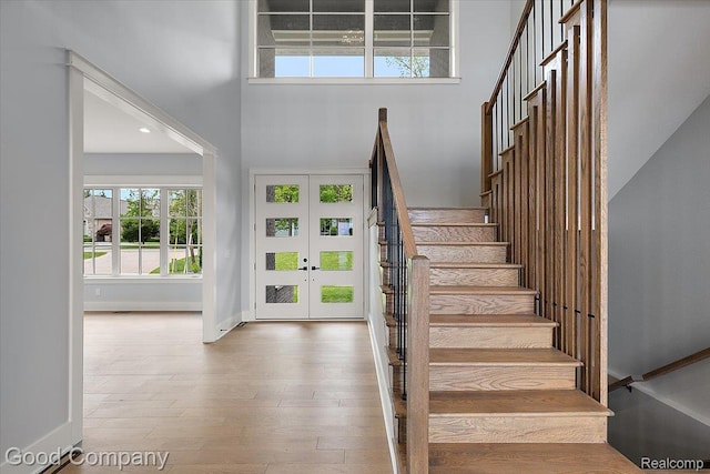 1760 Hamilton Dr, Bloomfield Hills, MI 48302 - staircase with french doors, plenty of natural light, a towering ceiling, baseboards, and wood finished floors