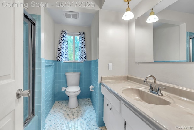 2408 Otter St, Warren, MI 48092 - bathroom featuring tile patterned floors, vanity, tile walls, an enclosed shower, and wainscoting