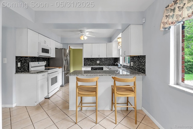 2408 Otter St, Warren, MI 48092 - kitchen featuring white appliances, a sink, healthy amount of natural light, and a peninsula