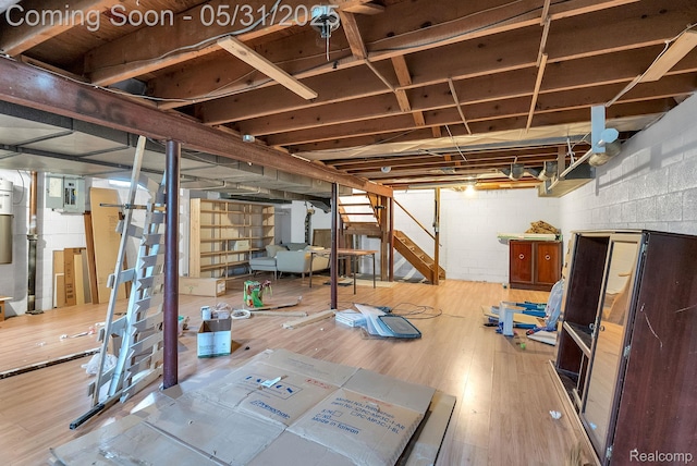 2408 Otter St, Warren, MI 48092 - unfinished basement featuring wood finished floors, concrete block wall, electric panel, and stairs