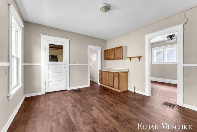 621 Olympia St SW, Grand Rapids, MI 49503 - unfurnished living room featuring dark wood-type flooring, ceiling fan, baseboards, and ornamental molding