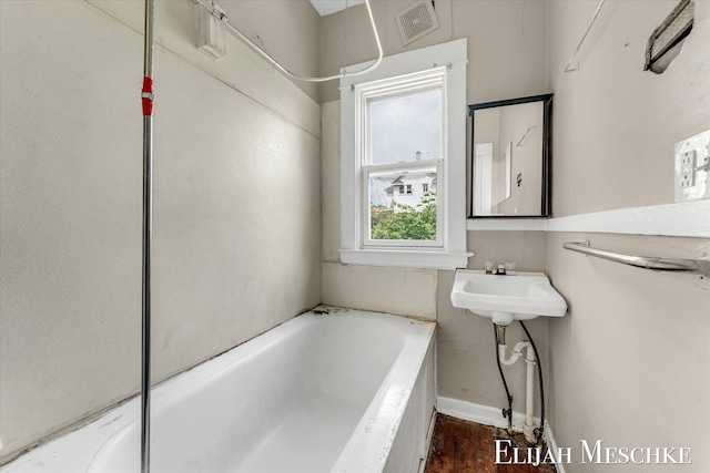 621 Olympia St SW, Grand Rapids, MI 49503 - bathroom featuring a garden tub, baseboards, and a sink