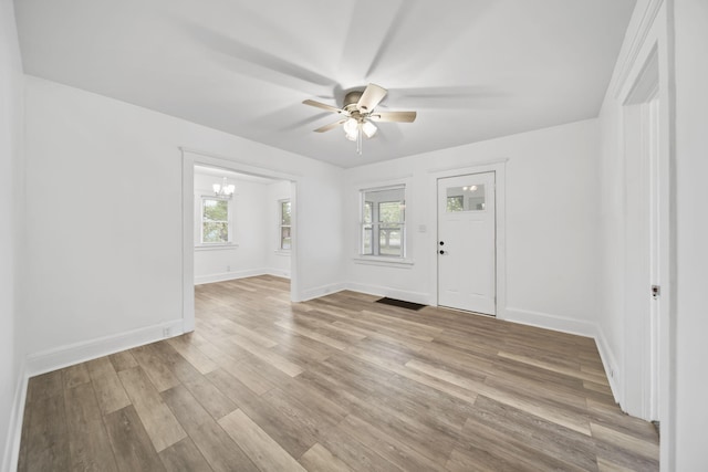 130 N Horton St, Jackson, MI 49202 - unfurnished room featuring a ceiling fan, a chandelier, light wood-type flooring, and baseboards