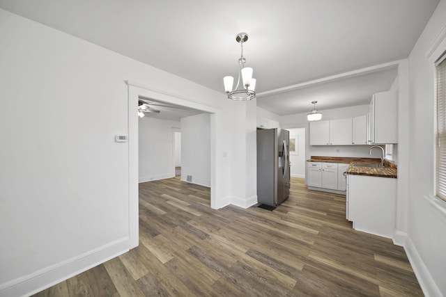 130 N Horton St, Jackson, MI 49202 - kitchen with stainless steel fridge, white cabinetry, dark wood-style floors, and baseboards