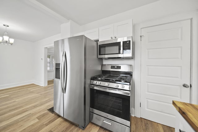 130 N Horton St, Jackson, MI 49202 - kitchen featuring appliances with stainless steel finishes, white cabinets, butcher block counters, a chandelier, and light wood-style flooring