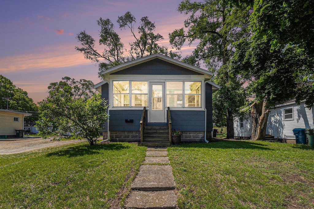 1273 Catherine Ave, Muskegon, MI 49442 - bungalow featuring a front yard and entry steps