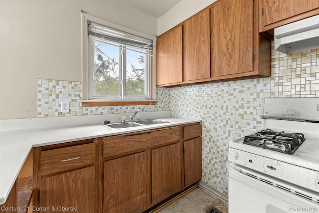 25960 Yale St, Inkster, MI 48141 - kitchen with white range with gas stovetop, under cabinet range hood, a sink, light countertops, and brown cabinetry