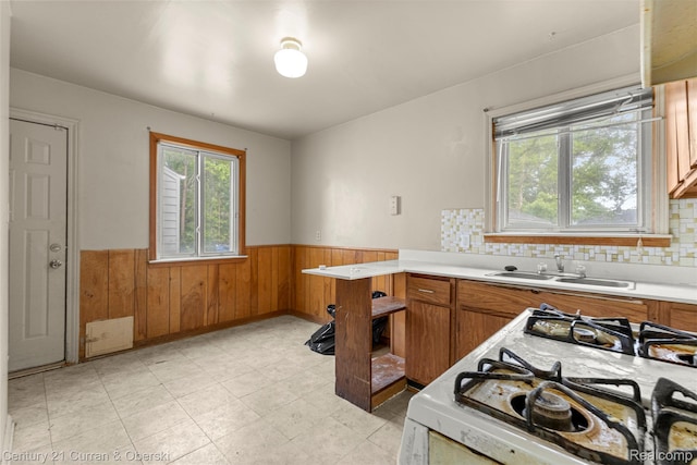 25960 Yale St, Inkster, MI 48141 - kitchen featuring a wainscoted wall, gas range, a sink, wood walls, and light countertops
