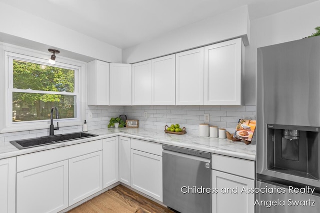 1328 S Montgomery St, Hastings, MI 49058 - kitchen with stainless steel appliances, a sink, backsplash, white cabinetry, and wood finished floors