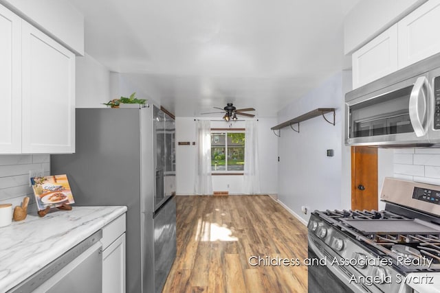 1328 S Montgomery St, Hastings, MI 49058 - kitchen featuring stainless steel appliances, a ceiling fan, decorative backsplash, and white cabinetry