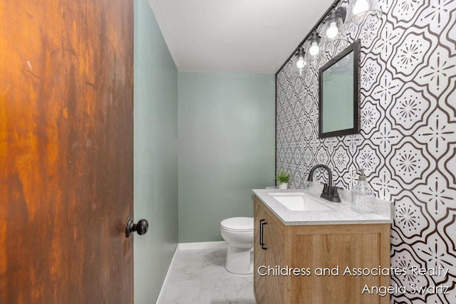 1328 S Montgomery St, Hastings, MI 49058 - half bathroom featuring baseboards, marble finish flooring, vanity, and toilet