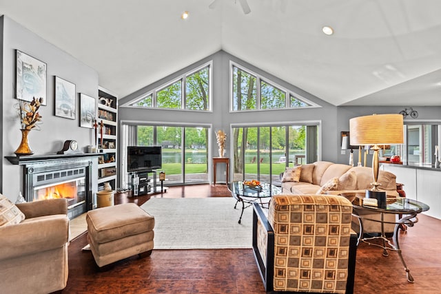 9228 Main St, Canadian Lakes, MI 49346 - living room with lofted ceiling, plenty of natural light, a glass covered fireplace, ceiling fan, and wood finished floors