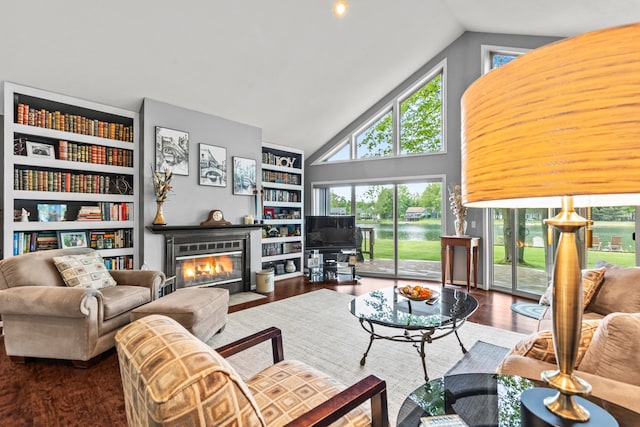 9228 Main St, Canadian Lakes, MI 49346 - living room with high vaulted ceiling, a fireplace with flush hearth, wood finished floors, and built in shelves