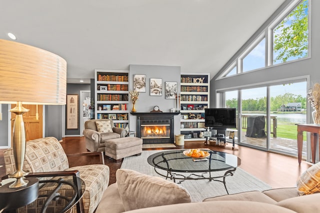 9228 Main St, Canadian Lakes, MI 49346 - living area featuring a fireplace with flush hearth, wood finished floors, built in features, recessed lighting, and lofted ceiling