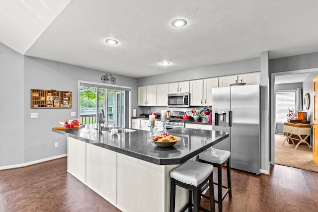 9228 Main St, Canadian Lakes, MI 49346 - kitchen featuring appliances with stainless steel finishes, a sink, dark wood finished floors, white cabinets, and a textured ceiling
