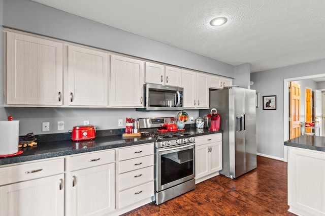 9228 Main St, Canadian Lakes, MI 49346 - kitchen with stainless steel appliances, dark countertops, a textured ceiling, dark wood-style floors, and baseboards