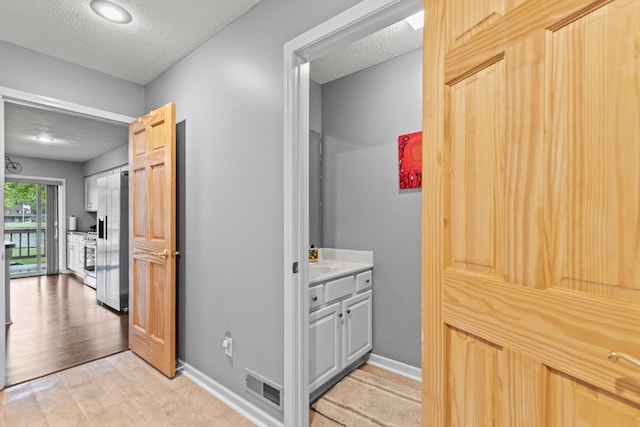 9228 Main St, Canadian Lakes, MI 49346 - bathroom with a textured ceiling, baseboards, and vanity