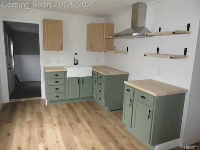 2220 E Bergin Ave, Burton, MI 48529 - kitchen featuring wall chimney exhaust hood, green cabinets, a sink, light wood-type flooring, and ornamental molding
