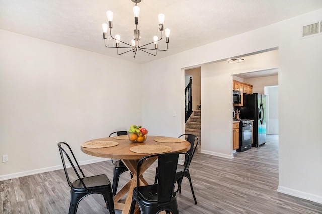 13860 Rolling Creek Dr, Lowell, MI 49331 - dining area featuring light wood-style flooring, baseboards, stairs, and a chandelier