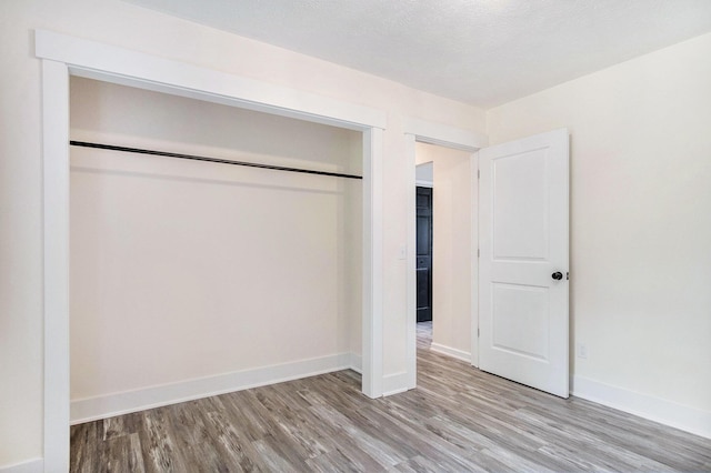 13860 Rolling Creek Dr, Lowell, MI 49331 - unfurnished bedroom featuring wood finished floors, baseboards, and a closet