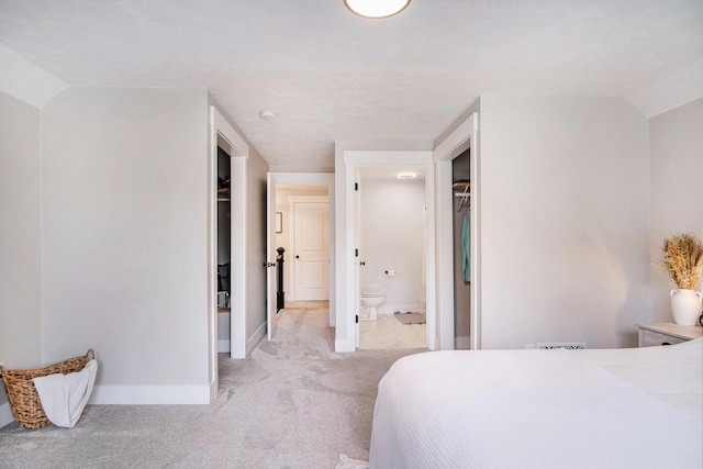 13860 Rolling Creek Dr, Lowell, MI 49331 - bedroom with light colored carpet, baseboards, ensuite bath, and lofted ceiling