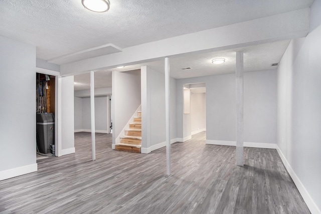 13860 Rolling Creek Dr, Lowell, MI 49331 - finished basement with wood finished floors, stairway, baseboards, and a textured ceiling