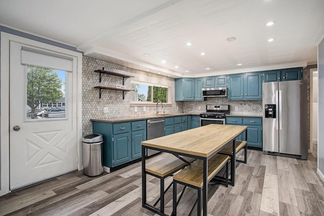 12657 Blue Lagoon Rd, Shelbyville, MI 49344 - kitchen with stainless steel appliances, blue cabinets, decorative backsplash, recessed lighting, and light wood-type flooring