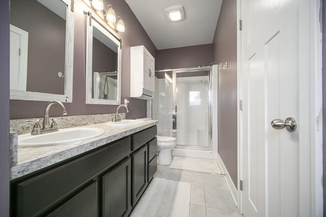 2842 Tall Grass Dr, Grass Lake, MI 49240 - bathroom with double vanity, a shower stall, toilet, tile patterned flooring, and baseboards