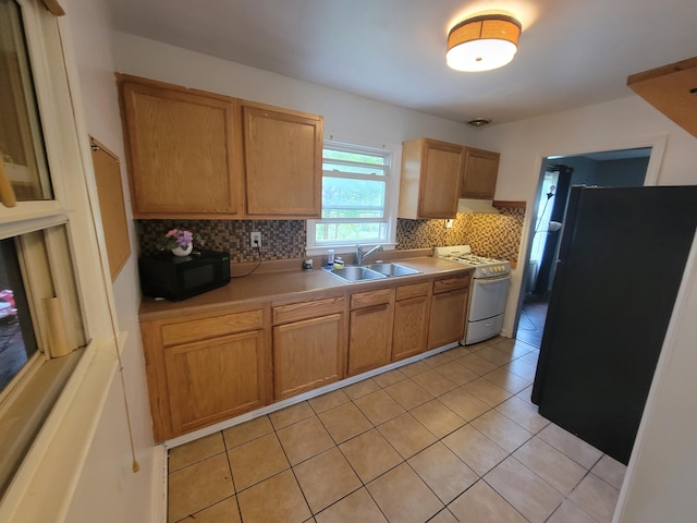 1607 Palmer Ave, Kalamazoo, MI 49001 - kitchen featuring black appliances, a sink, decorative backsplash, light tile patterned floors, and light countertops