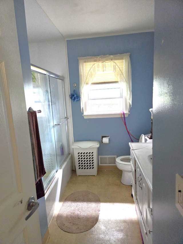 617 Stoll Rd, Lansing, MI 48917 - full bath featuring toilet, vanity, and bath / shower combo with glass door
