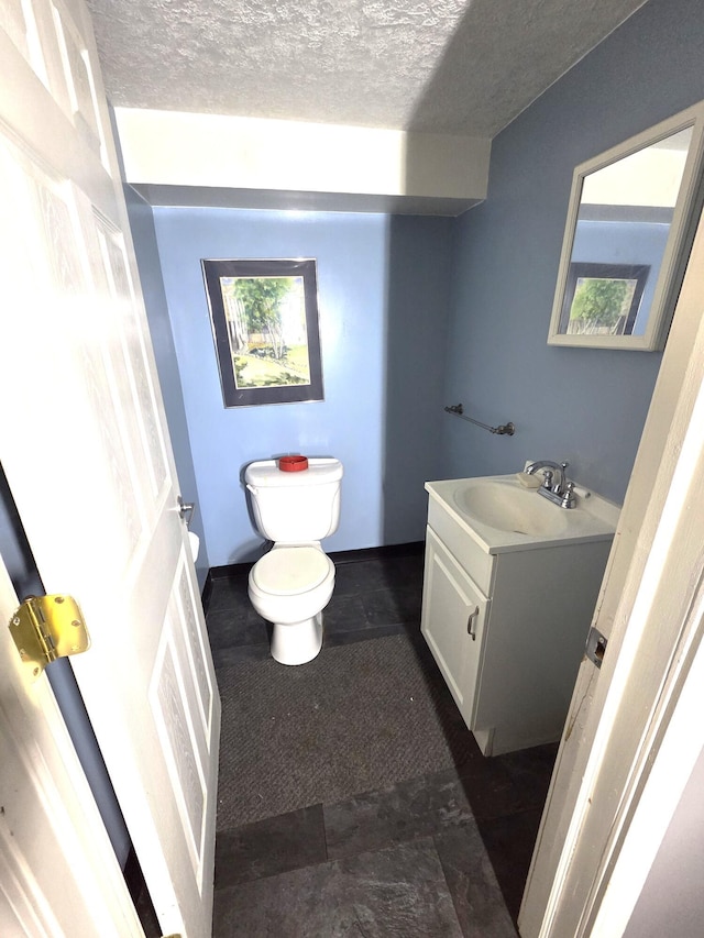 617 Stoll Rd, Lansing, MI 48917 - bathroom with vanity, toilet, and a textured ceiling