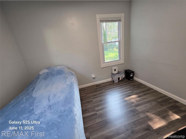 12725 Riverview St, Detroit, MI 48223 - unfurnished bedroom featuring baseboards and dark wood finished floors