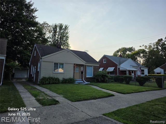 12725 Riverview St, Detroit, MI 48223 - bungalow-style house featuring driveway, brick siding, entry steps, a chimney, and a detached garage