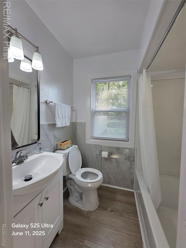 12725 Riverview St, Detroit, MI 48223 - full bathroom featuring tile walls, vanity, wood finished floors, shower / bath combo, and a wainscoted wall