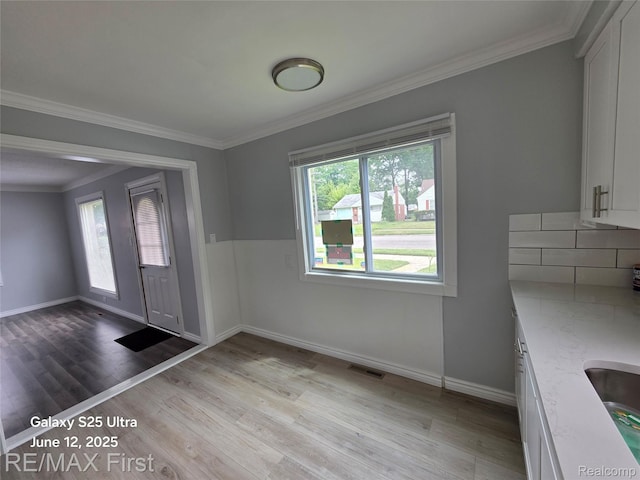 12725 Riverview St, Detroit, MI 48223 - unfurnished dining area featuring plenty of natural light, light wood-style floors, and ornamental molding