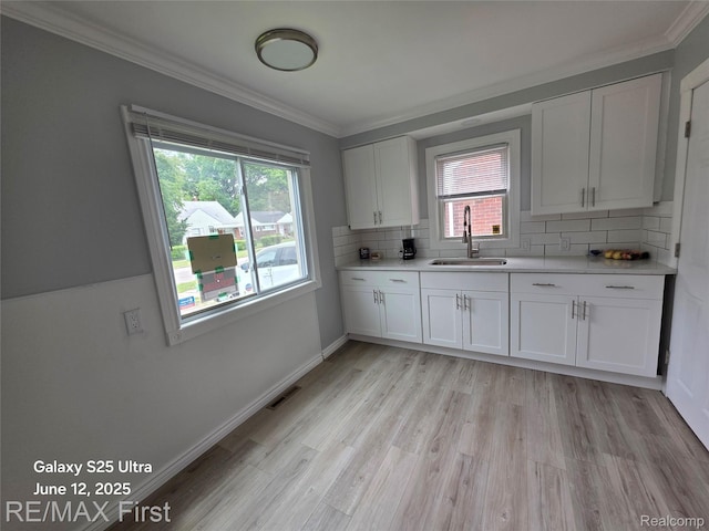 12725 Riverview St, Detroit, MI 48223 - kitchen featuring light countertops, healthy amount of natural light, decorative backsplash, and ornamental molding