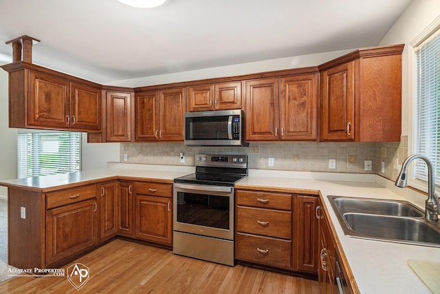 6063 Steeplechase Dr, Grand Blanc, MI 48439 - kitchen with appliances with stainless steel finishes, a sink, a peninsula, and plenty of natural light